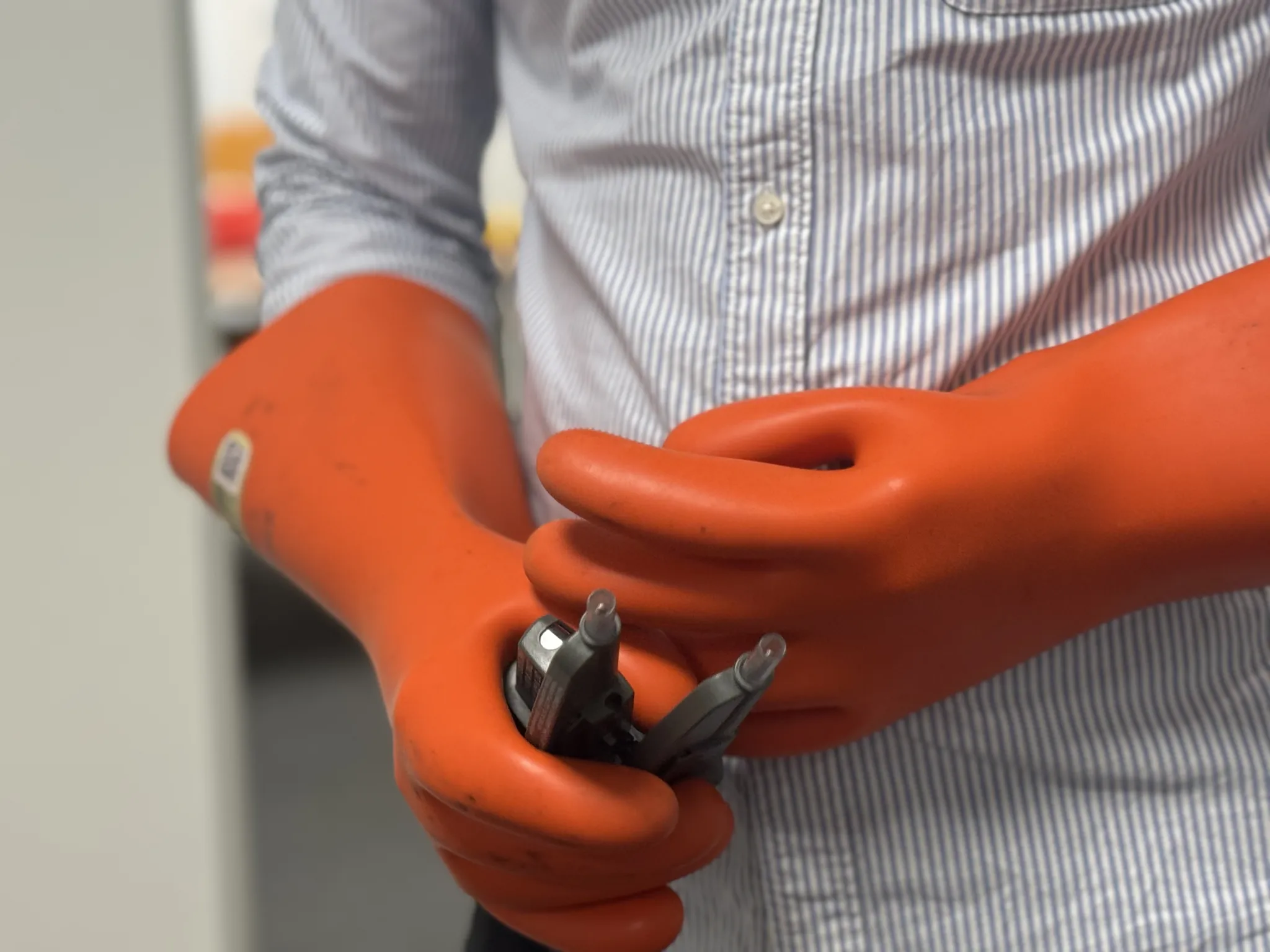 Gants de protection orange tenant des outils électriques